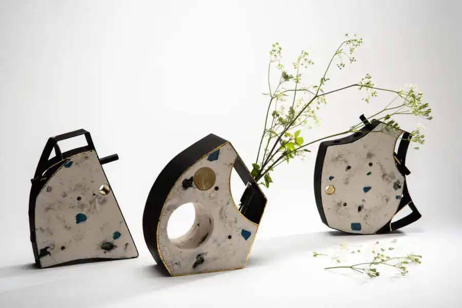 Vintage concrete pendant lights with black handles and delicate green foliage, minimalist decor styl.