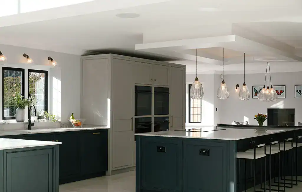 Bright kitchen featuring pendant lights, white cabinets, and a spacious island.