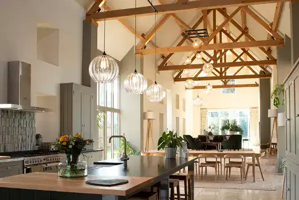 Contemporary kitchen featuring wooden ceiling beams and stylish pendant lights, creating a warm and.