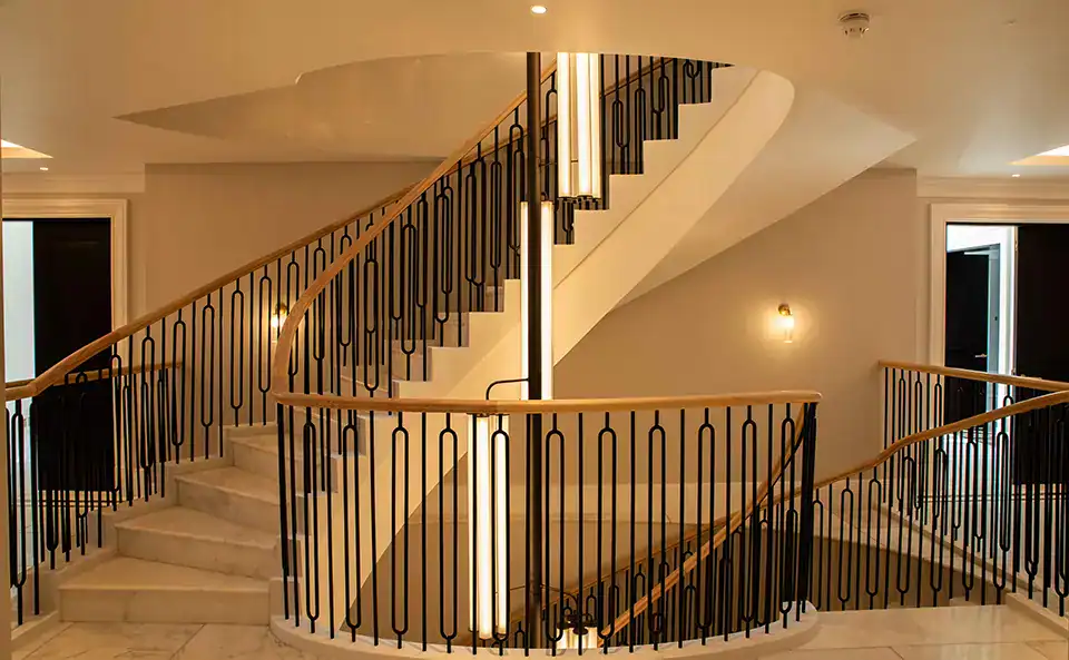 A bespoke Alton chandelier in a bronze metal finish in a narrow stairwell with an 11.5 metre drop
