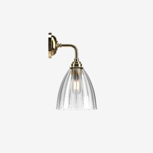 Contemporary wall light with glass shade and brass finish for bathroom decor.