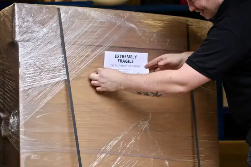 Extremely fragile packaging warning sign on wooden crate.