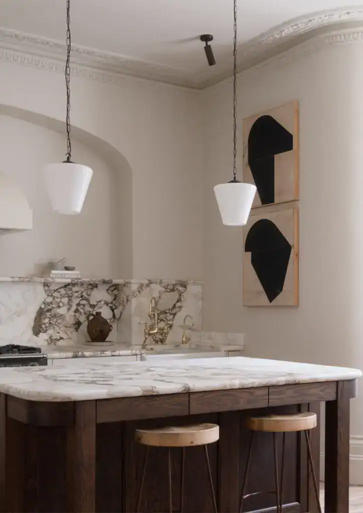 Elegant kitchen with modern lighting fixtures and abstract wall art.