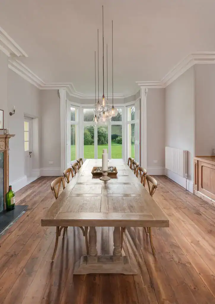 Elegant dining room with modern lighting and large bay window.