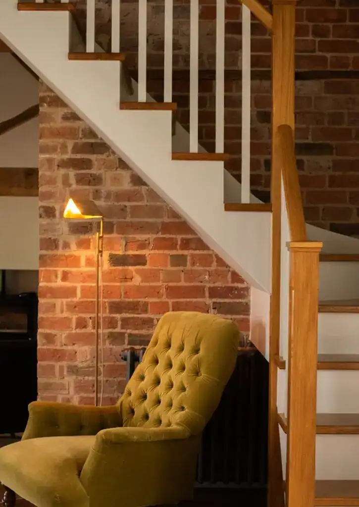 Warm ambient lighting beside a vintage armchair.