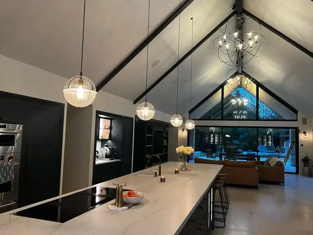 Modern kitchen with pendant lighting and high vaulted ceiling.