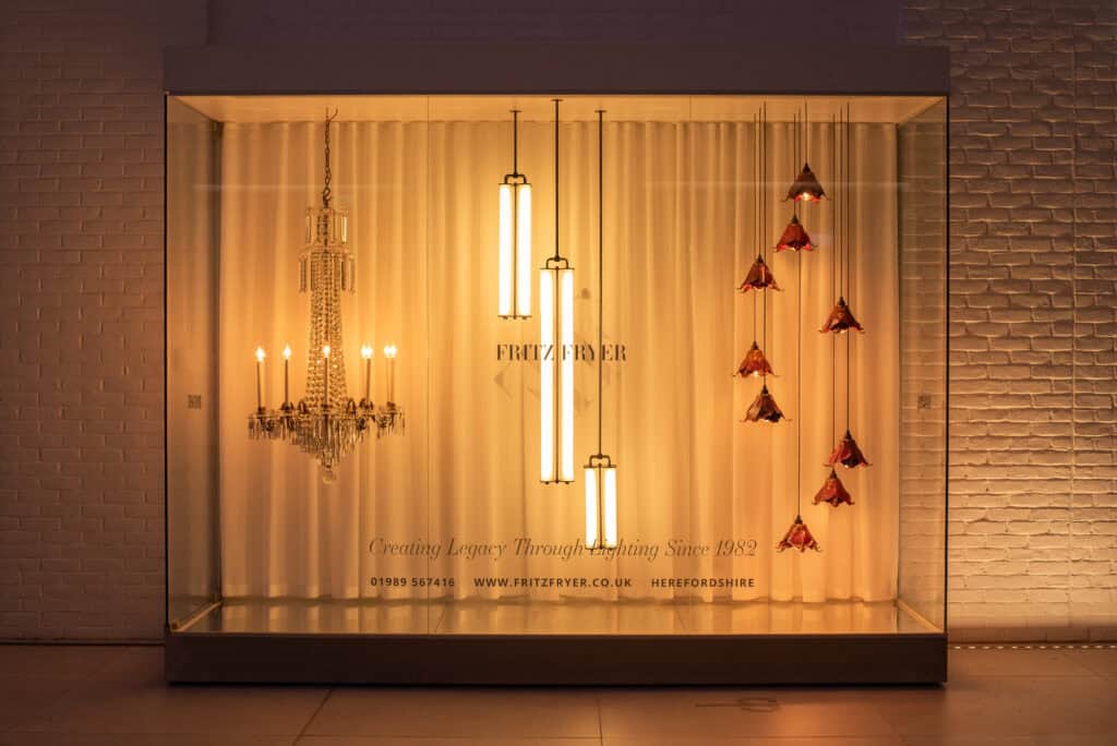 Elegant lighting display with chandelier and pendant lights at Fritz Fryer Lighting UK.