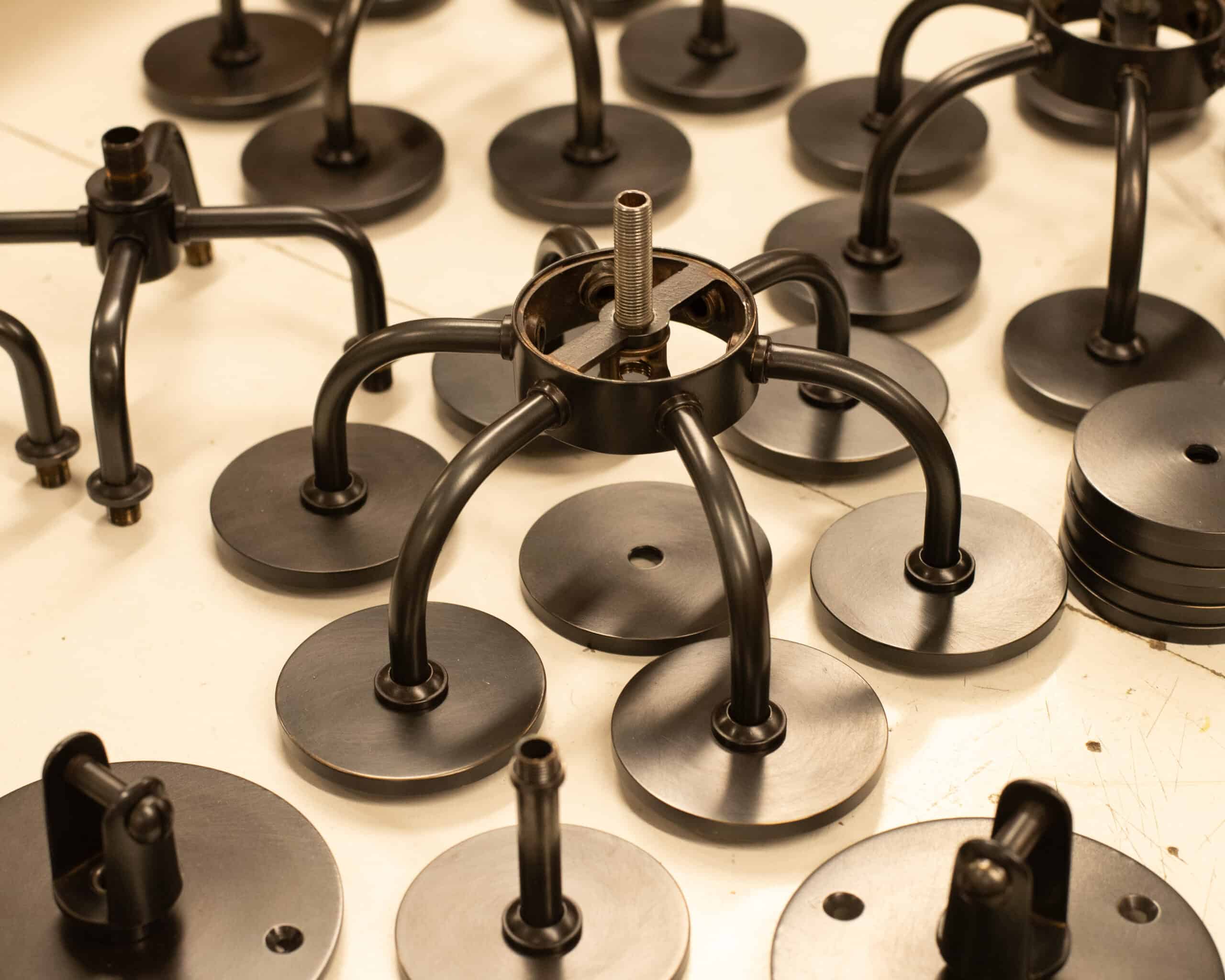 Various black lighting fixtures and components on a workbench.