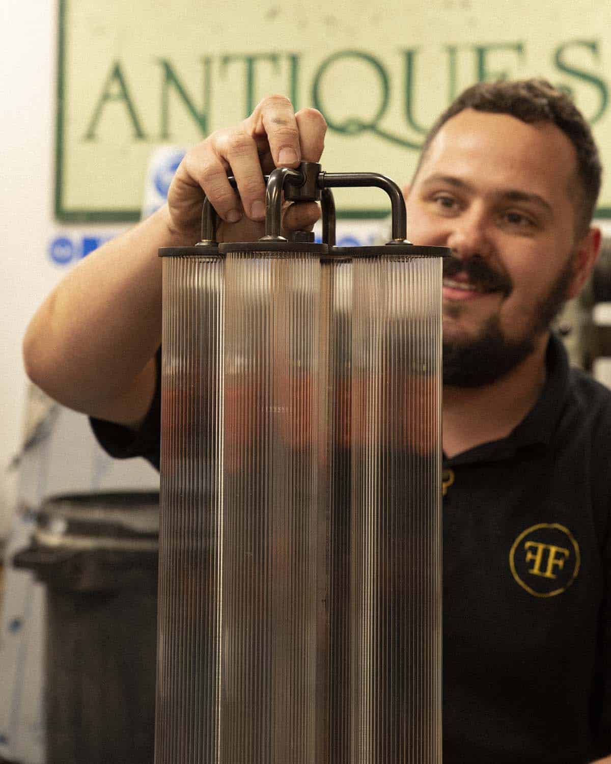 Man holding vintage antique lantern at Fritz Fryer Lighting UK.